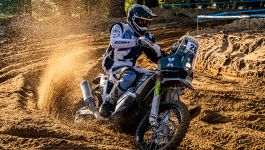 Konrad Dąbrowski jedzie motocyklem, wzbijając za sobą chmurę piasku. Polski zawodnik w rajdowym kombinezonie i kasku koncentruje się na utrzymaniu równowagi w trudnym terenie. W tegorocznej edycji rajdu wygrał jeden z etapów i zajął dziewiąte miejsce w klasyfikacji ogólnej motocyklistów (fot. Getty)