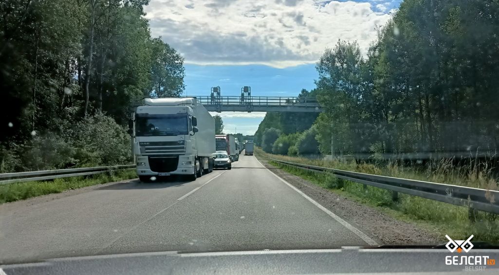 Нешматлікія легкавыя аўтамабілі мінаюць 15-кіламетровую чаргу да мяжы. Большасць з іх мае беларускую рэгістрацыю, астатнія – польскія. Баброўнікі, 6 ліпеня 2022 г. (Фота: Пётр Яворскі / Белсат)