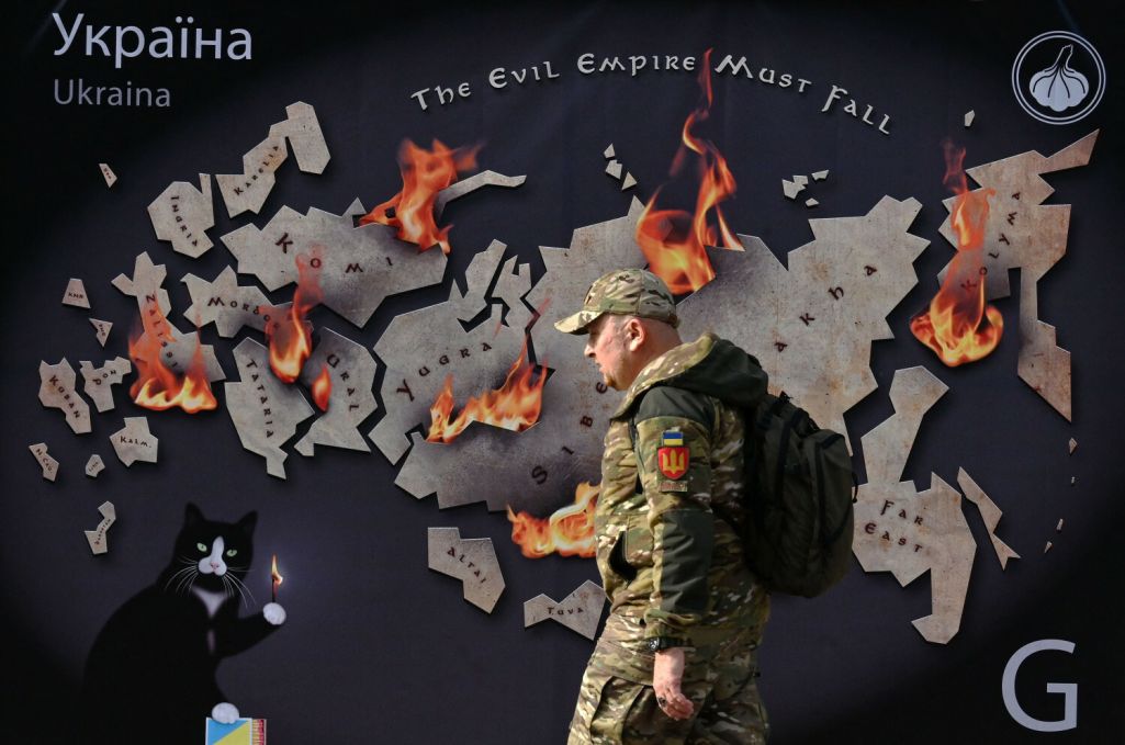 Здымак мае ілюстрацыйны характар. Украінскі вайсковец праходзіць міма банэра з выявай Расеі ў агні са словамі «Імперыя зла павінна ўпасці» ў цэнтры Кіева, Украіна. 26 кастрычніка 2023 года. (Фота: Sergei Supinsky / AFP / East News)