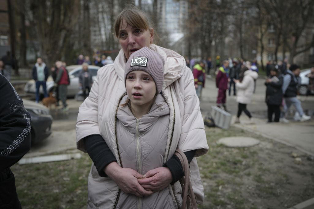 Жыхары Пячэрскага раёну Кіева стаяць каля пашкоджанага ў вы (Фота: Vadim Ghirda / AP Photo / East News)