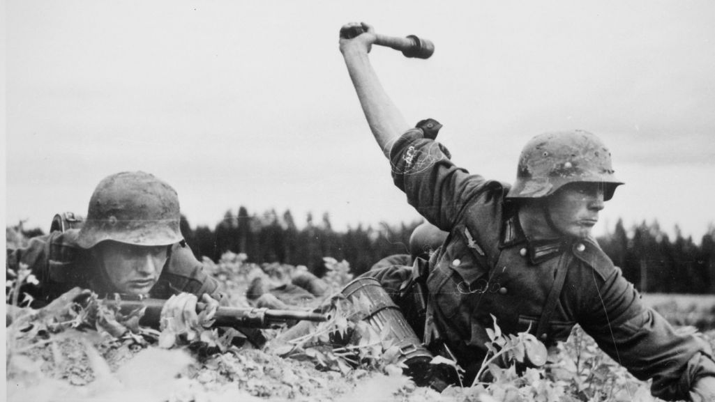 Na zdjęciu przedstawieni dwaj niemieccy żołnierze o nieustalonej tożsamości. Jeden z nich rzuca granatem (stielhandgranate), drugi ma w rękach karabinek Mauser Kar98k. Fot. Wikimedia/ domena publiczna