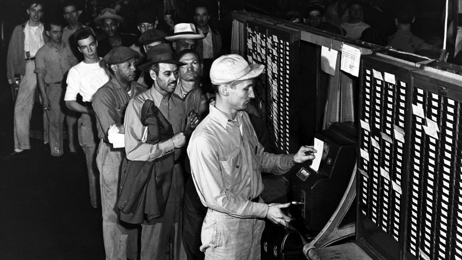 Robotnicy czekają w kolejce na odbicie swojej karty w zegarze, rozpoczynając zmianę w fabryce należącej do Ford River Rouge Complex w Dearborn w stanie Michigan. Fot. George Rinhart / Corbis via Getty Images