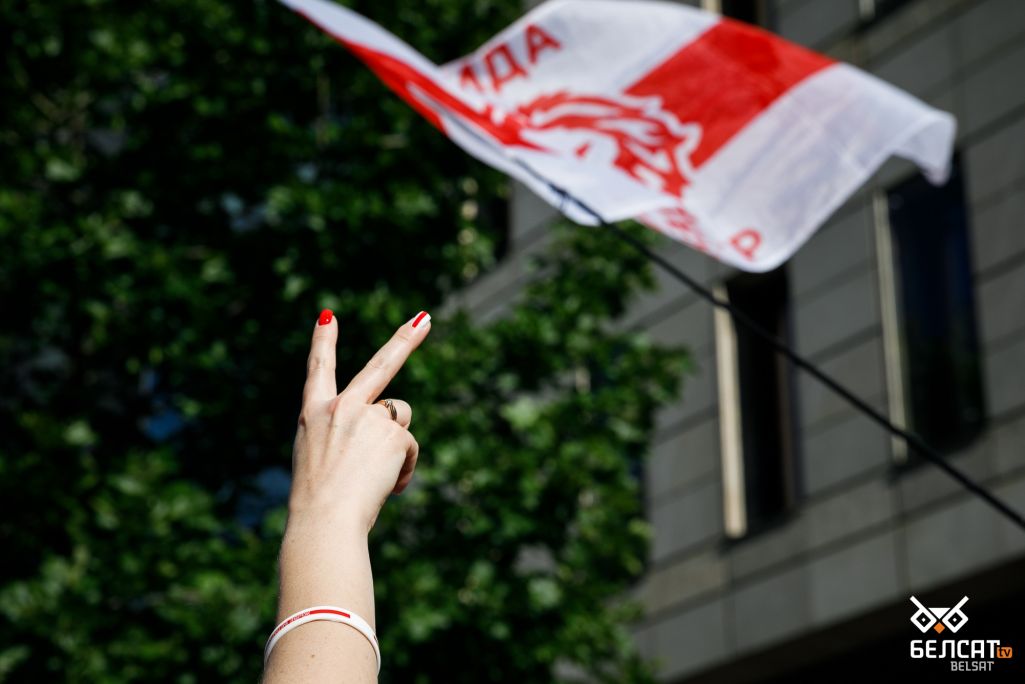 Здымак мае ілюстрацыйны характар. Дзяўчына з манікюрам у белым і чырвоным колерах паказвае знак «V» каля будынку Еўракамісіі ў цэнтры Варшавы падчас Маршу годнасці, прысвечанага другой гадавіне пратэстаў, якія паўсталі пасля фальсіфікацыі прэзідэнцкіх выбараў у Беларусі. Варшава, Польшча. 7 жніўня 2022 года. (Фота: Таццяна Верамеева / Белсат)